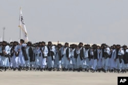 بگرام ایئر بیس کی پریڈ میں طالبان جنگجوؤں کا ایک دستہ تین سالہ قبضے کا جشن منا رہا ہے۔ 14 اگست 2024